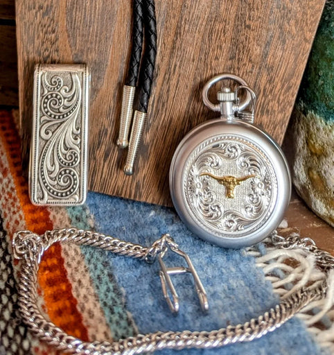 Western Bling Collection, featuring an intricately engraved silver money clip, a classic bolo tie with black leather cords, and a detailed pocket watch .
