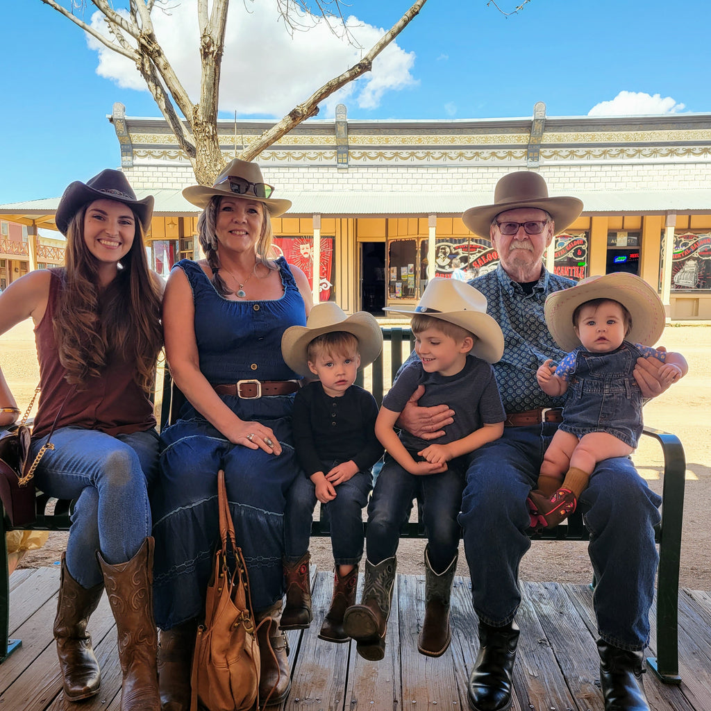 Family of grandparents, parents and kids wearing western hats