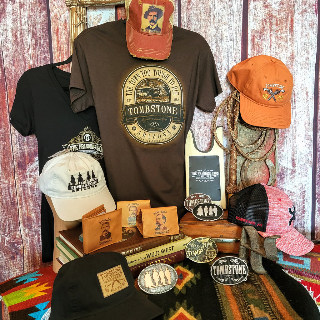 a selection of tee shirts, caps, wallets and belt buckle with tombstone or Branding Iron