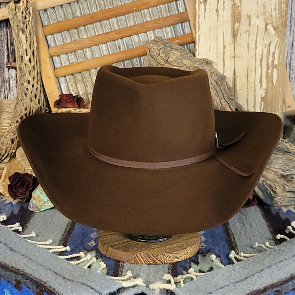 Brown wool cowboy hat with a brown band tied with a silver detail.