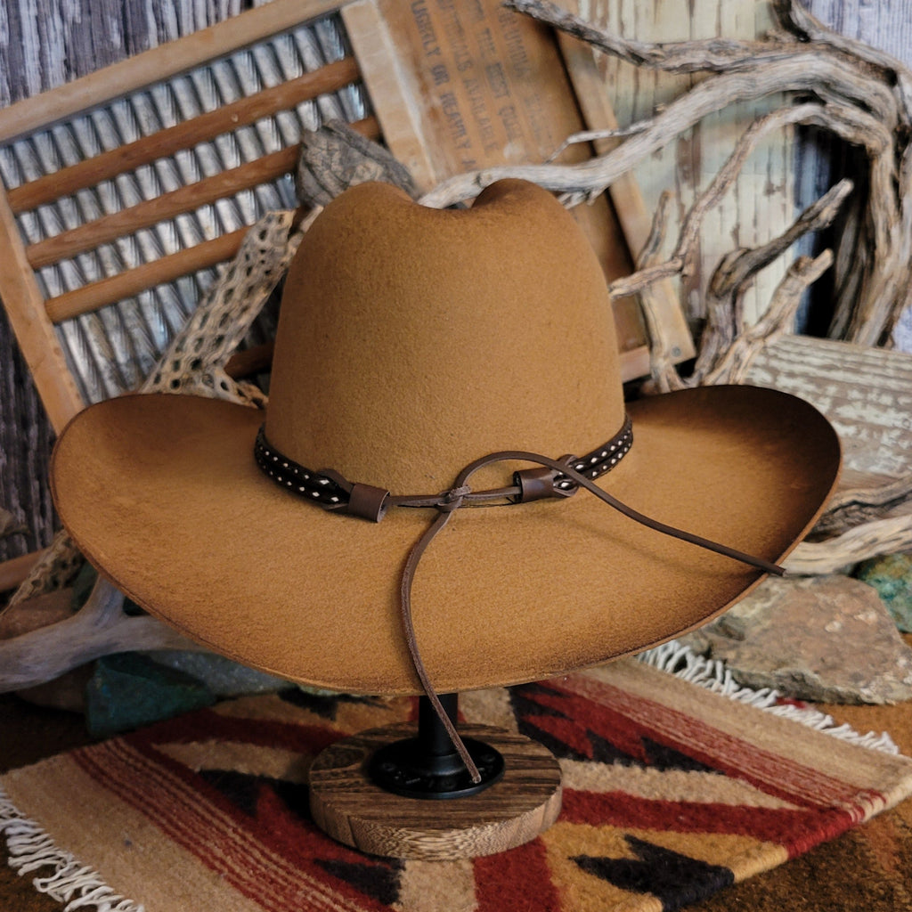 Brown cowboy hat with rustic finish and a brown and white hat band.