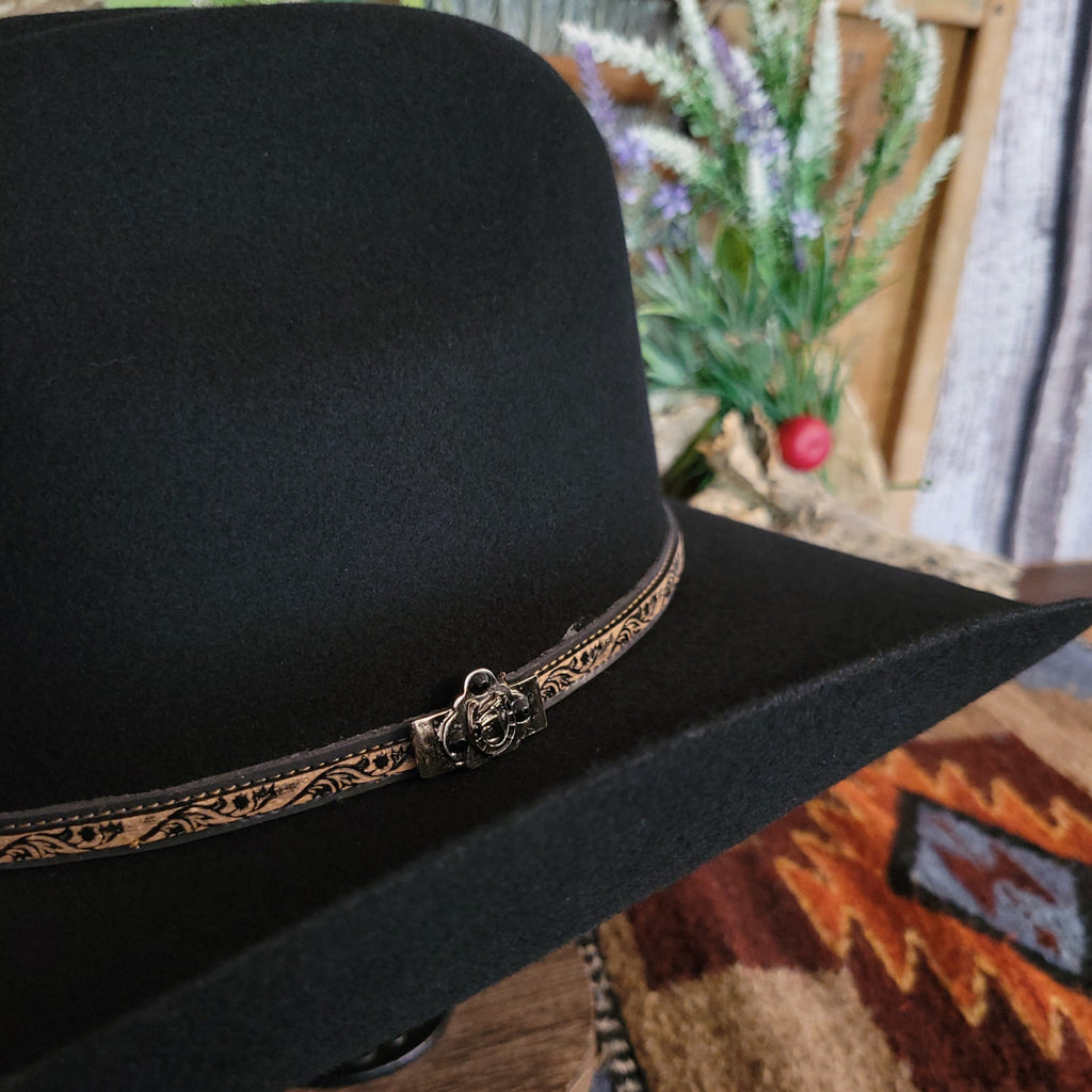 A close-up of the decorative leather hat band with black stitching and black, beaded silver detail.