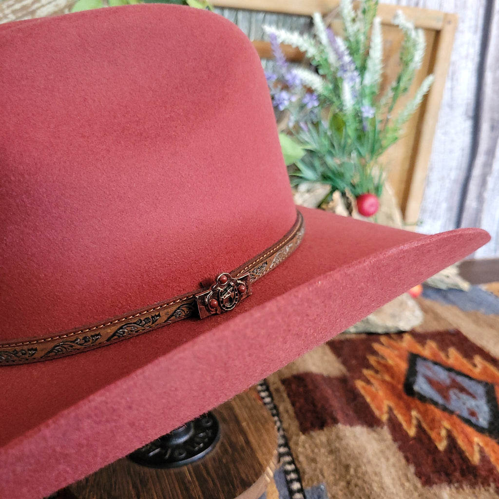 A close-up of the decorative leather hat band with silver detail and red beads.