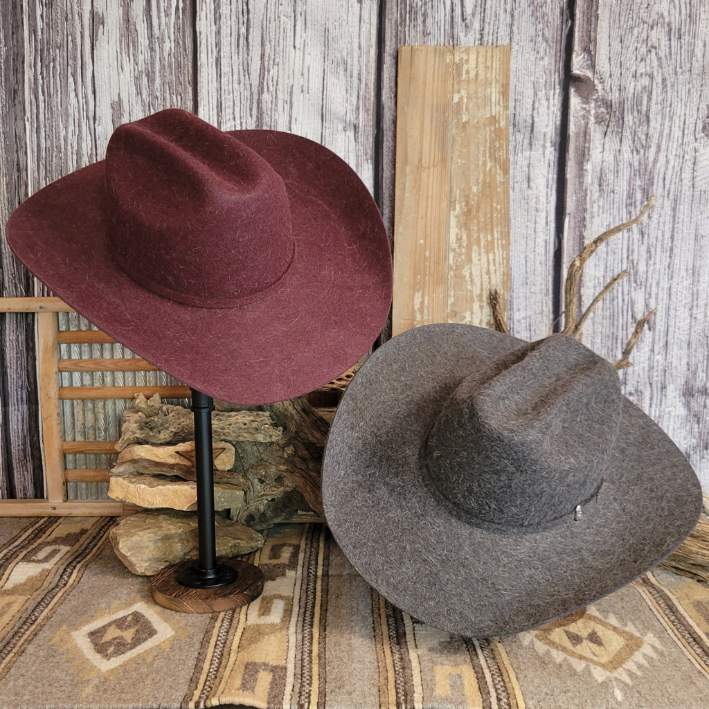 Two western hats in the colors of gray and burgundy.