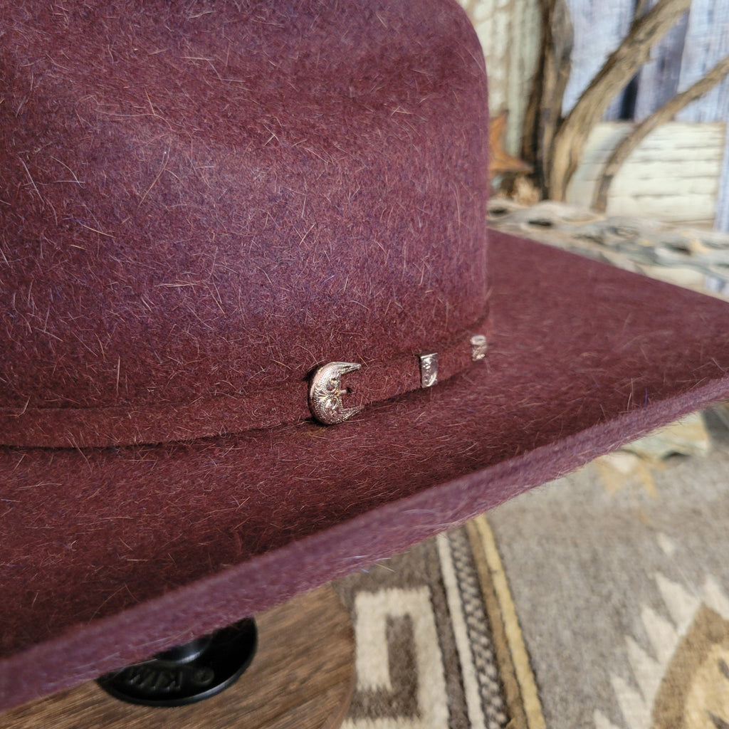 Close up of the small silver buckle on the hat's band.