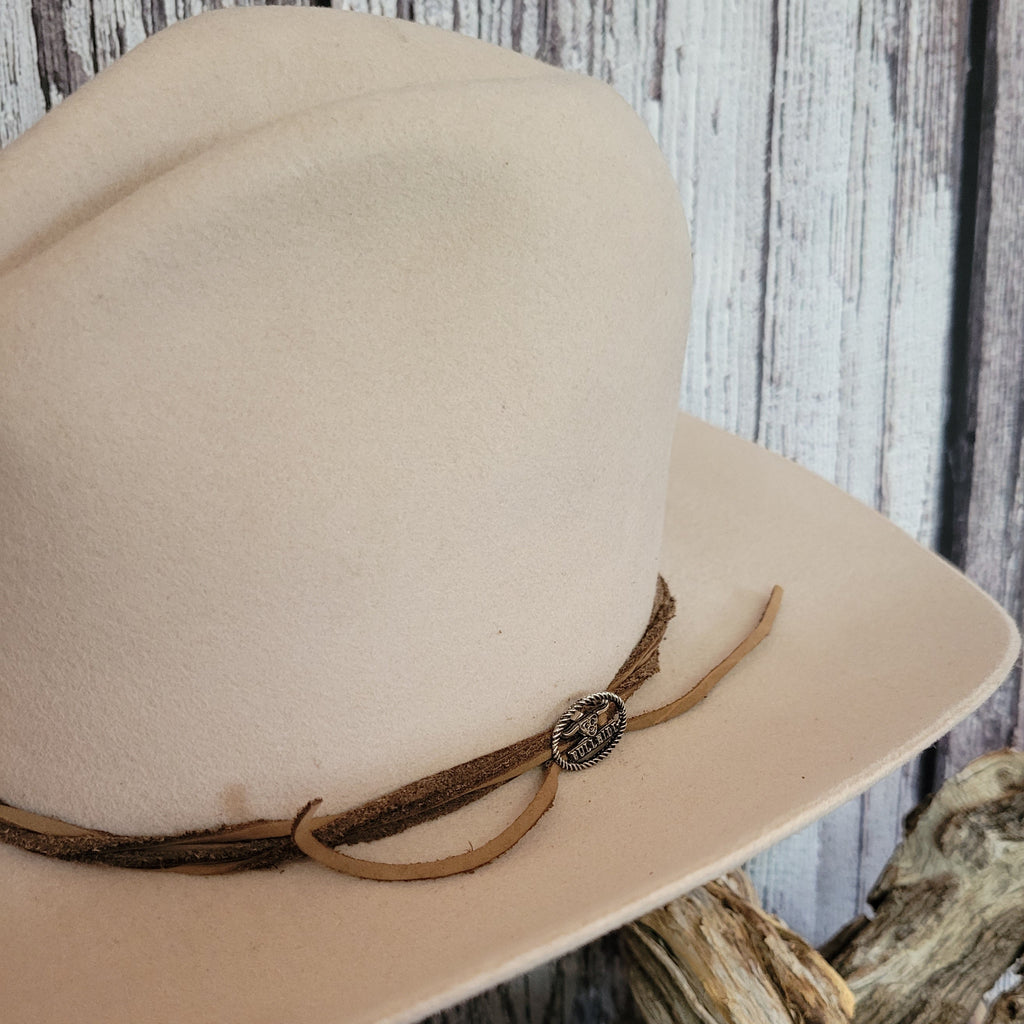 Close-up of the brand's charm at the ties of the hat band.