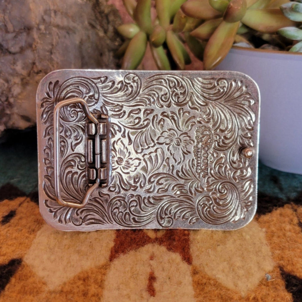 Tooled engravings on the back of the belt buckle.