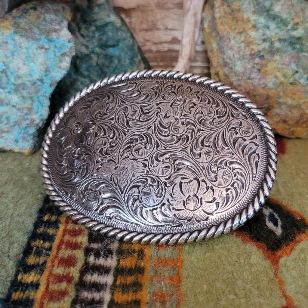 Ornate detailed silver-plated belt buckle with twisted rope design.
