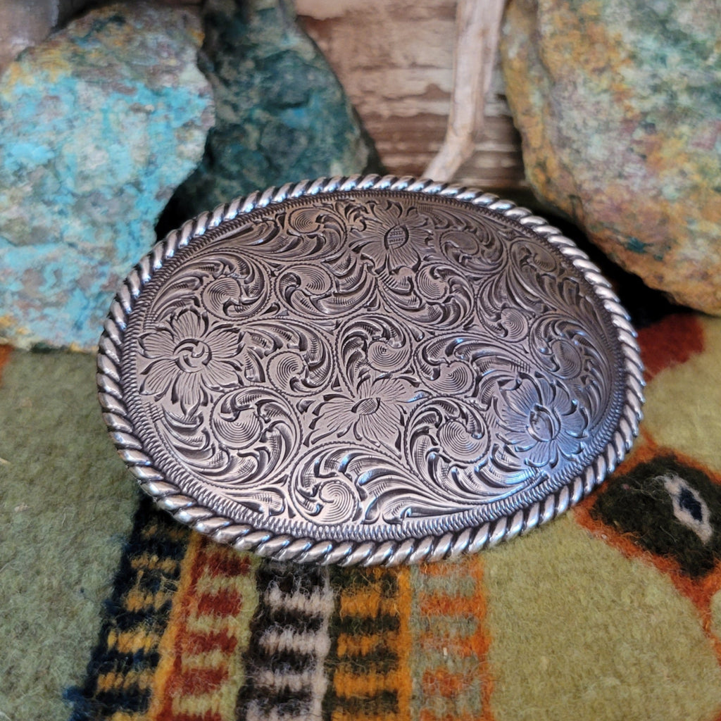 Ornate detailed silver-plated belt buckle with twisted rope design.