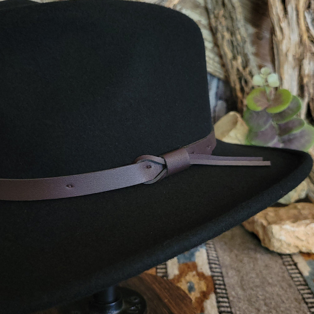 A close-up of the brown leather band knotted at the side.