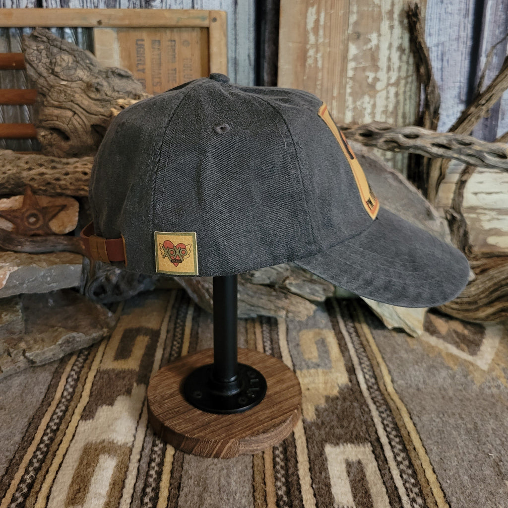 Black cap with a curved bill, displaying distressed fabric and reinforced stitching.