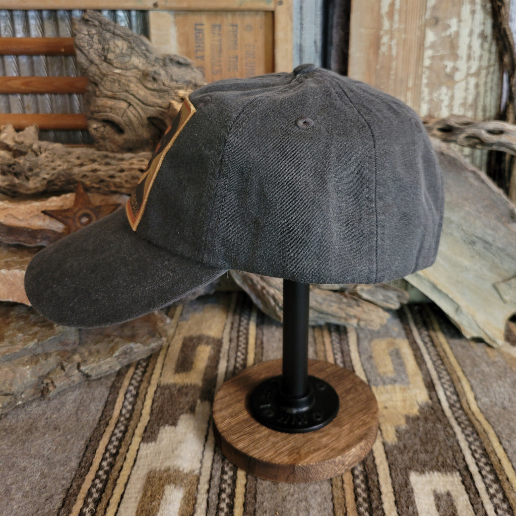 Black cap with a curved bill, displaying distressed fabric and reinforced stitching.