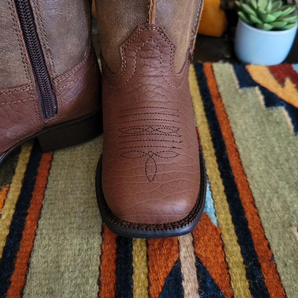 Detail view of the stitched detail on the front and zipper closure on the side of the boot.
