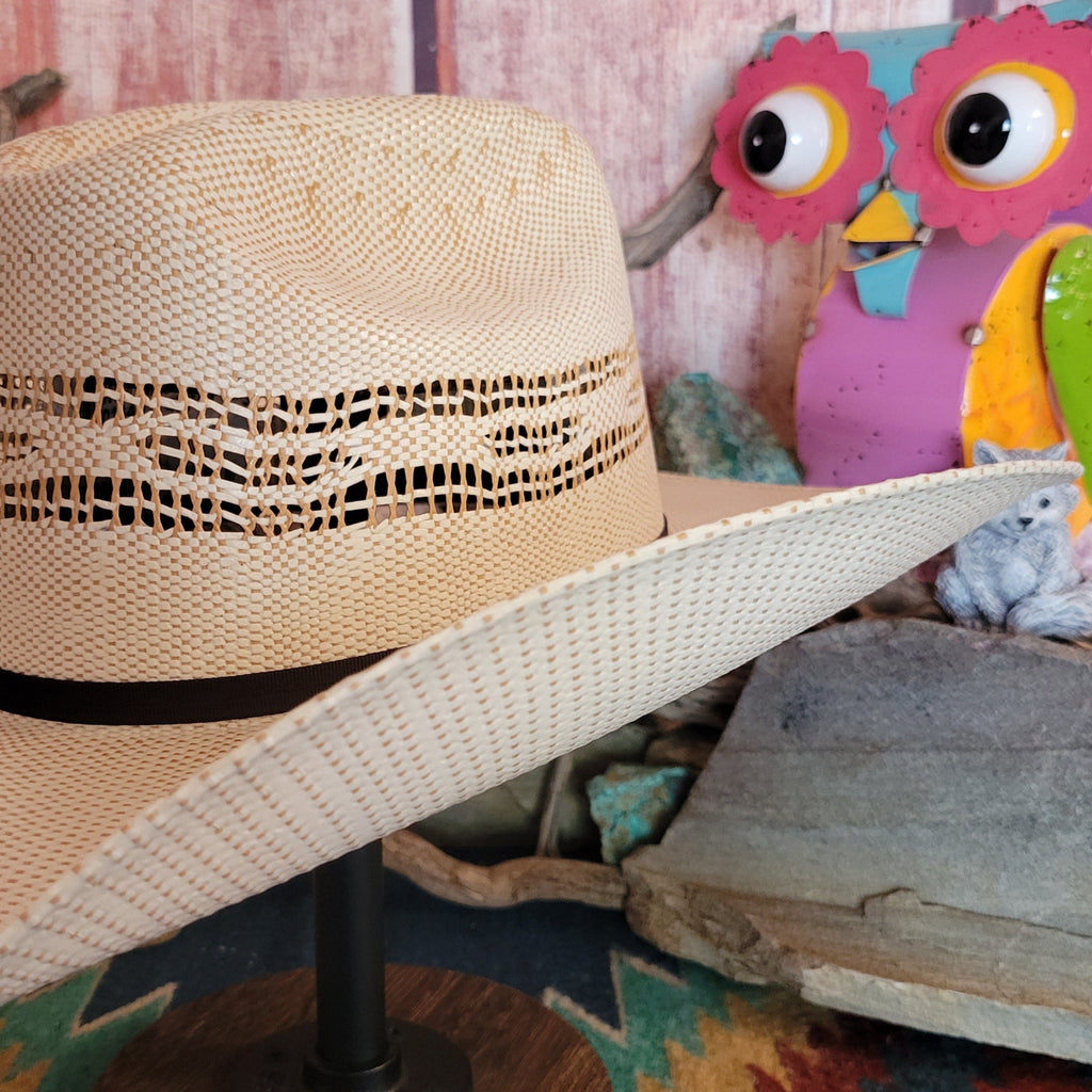 Close-up shows the woven band’s texture against the straw’s weave.