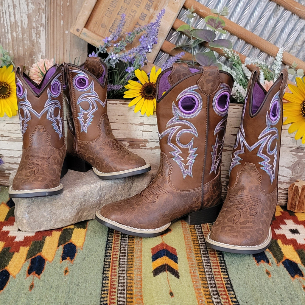 A brown faux-leather kids' boot with a leopard print pattern and purple stitched accents.