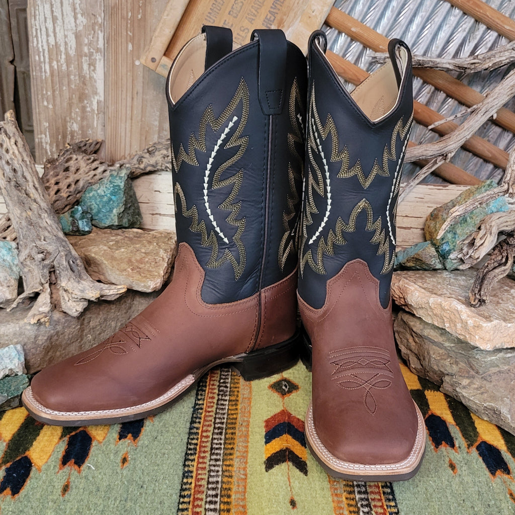 Kids' brown leather boots with black shafts, featuring ornate stitching and a squared toe.