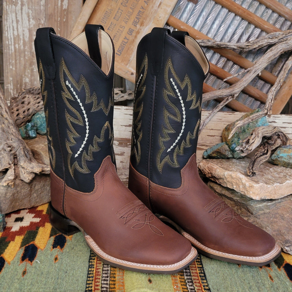 Kids' brown leather boots with black shafts, featuring ornate stitching and a squared toe.
