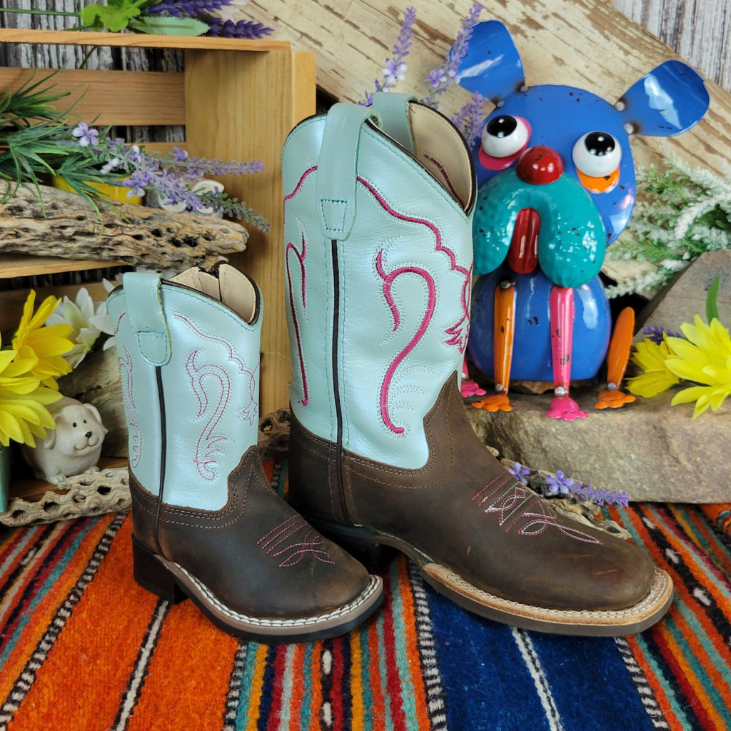 Pair of cowboy boots with teal shaft with bright red designs and dark brown leather toe.