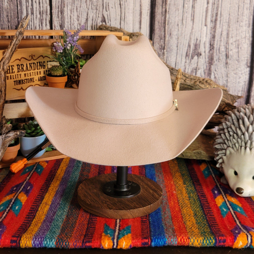 Cream colored wool hat with thin hat band and gold buckle detail.