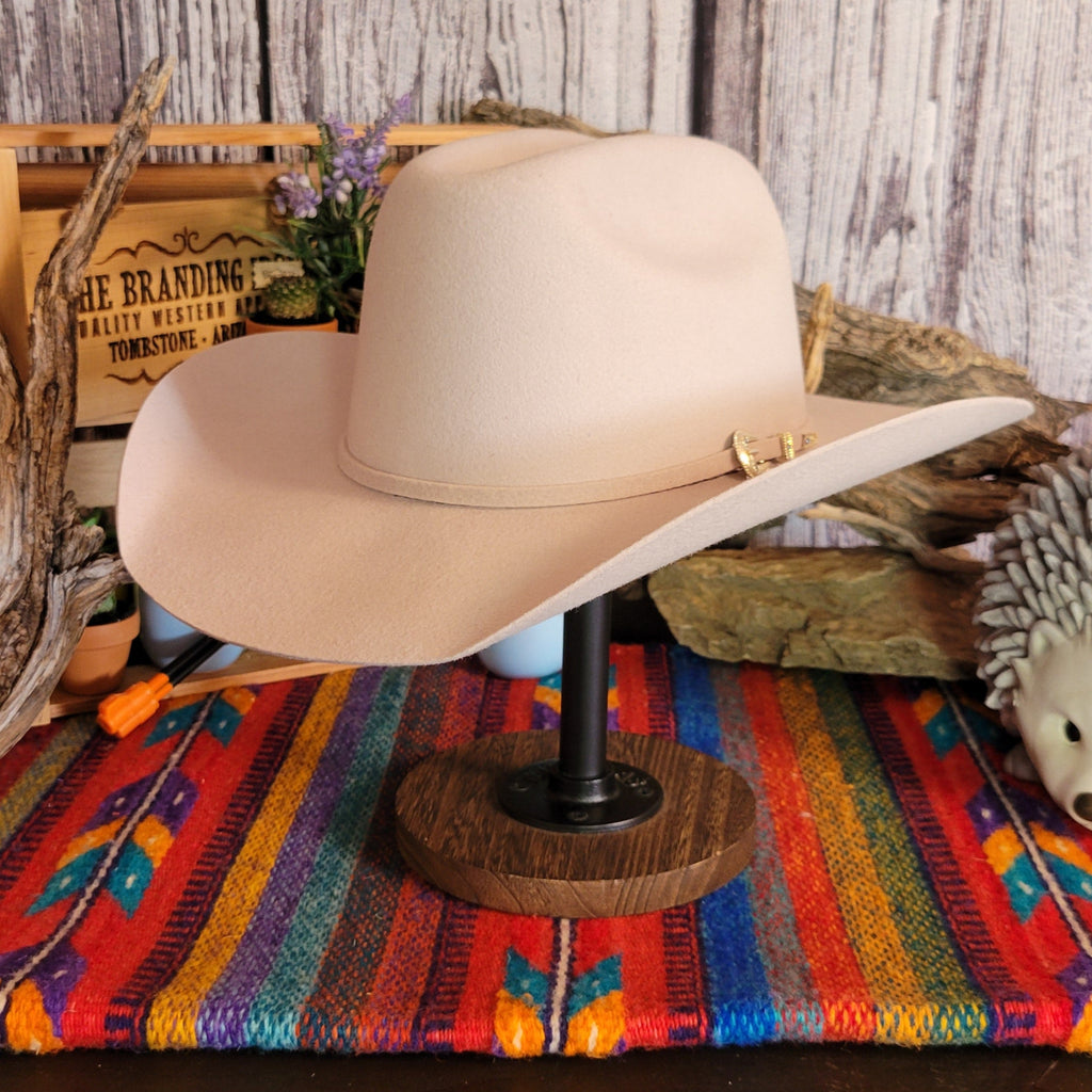 Cream colored wool hat with thin hat band and gold buckle detail.