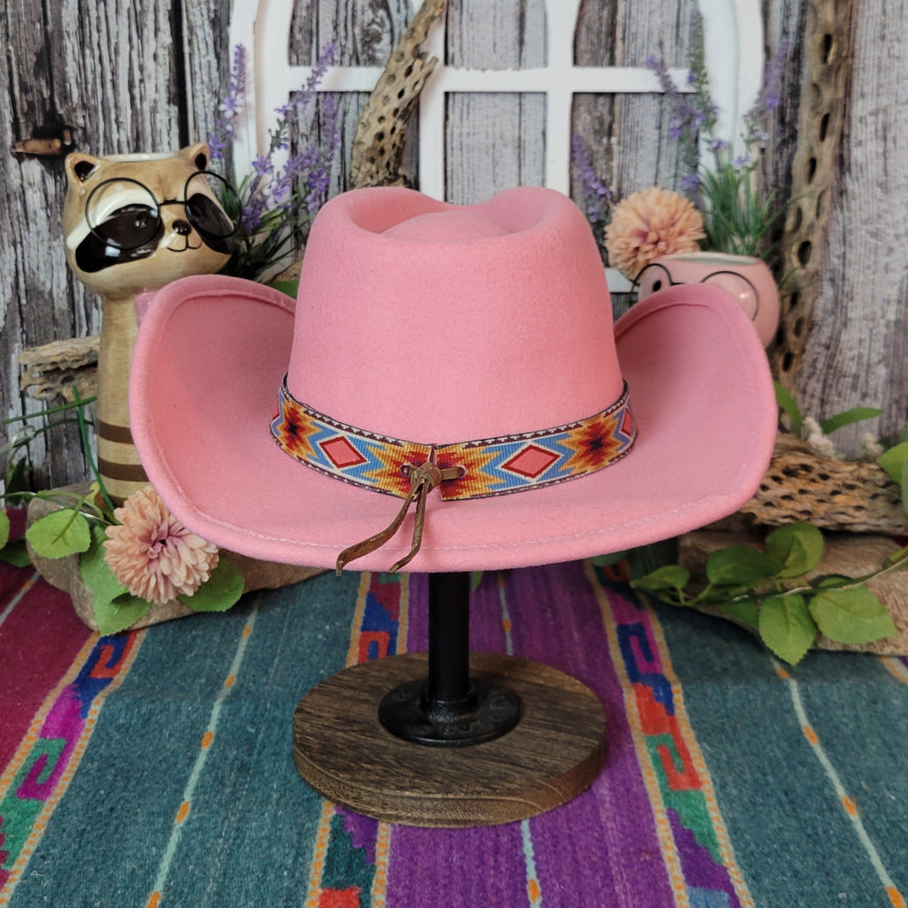 Pink wool kids' hat with a colorful geometric band and pull cords.