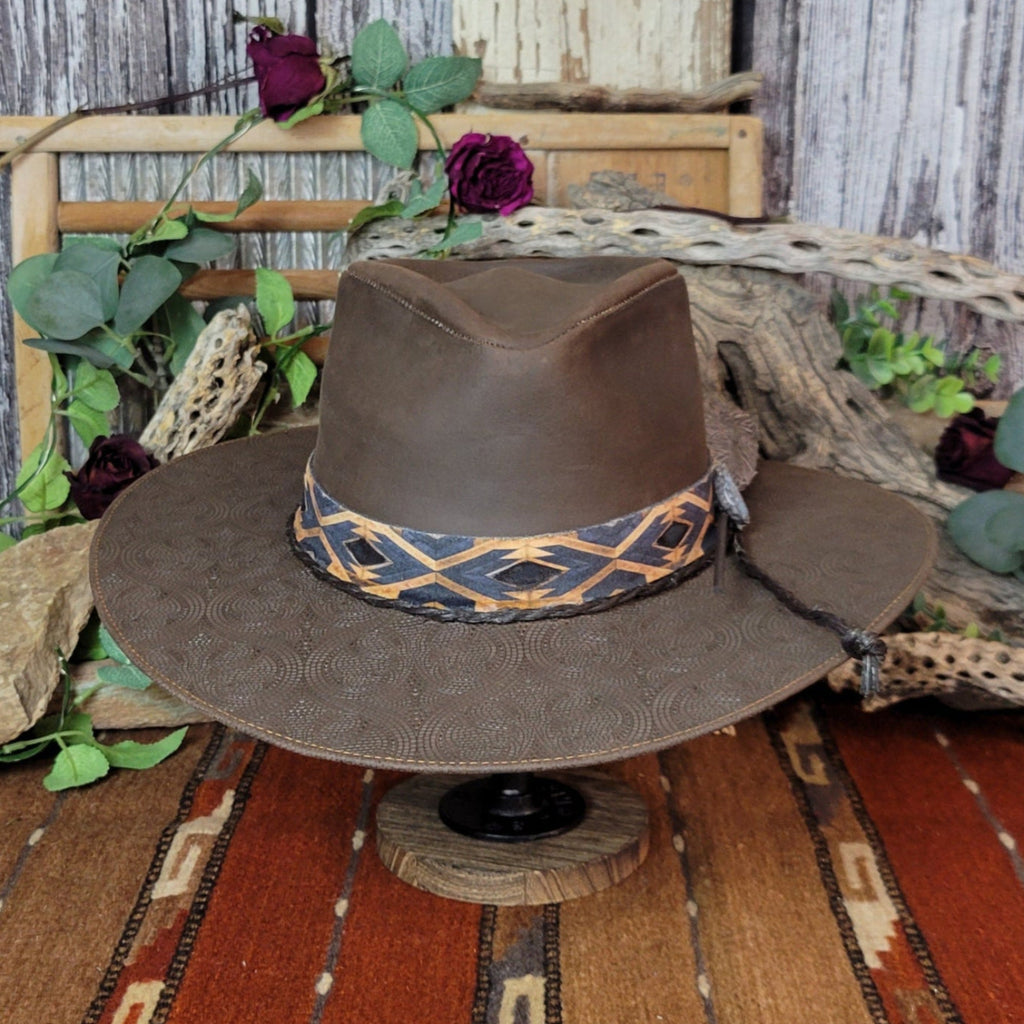 A brown leather hat with a diamond-patterned band.
