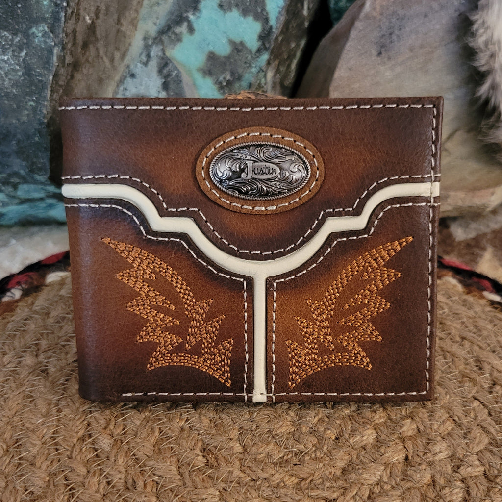Burnished tan leather wallet with tooled yoke design and ornate silver concho.