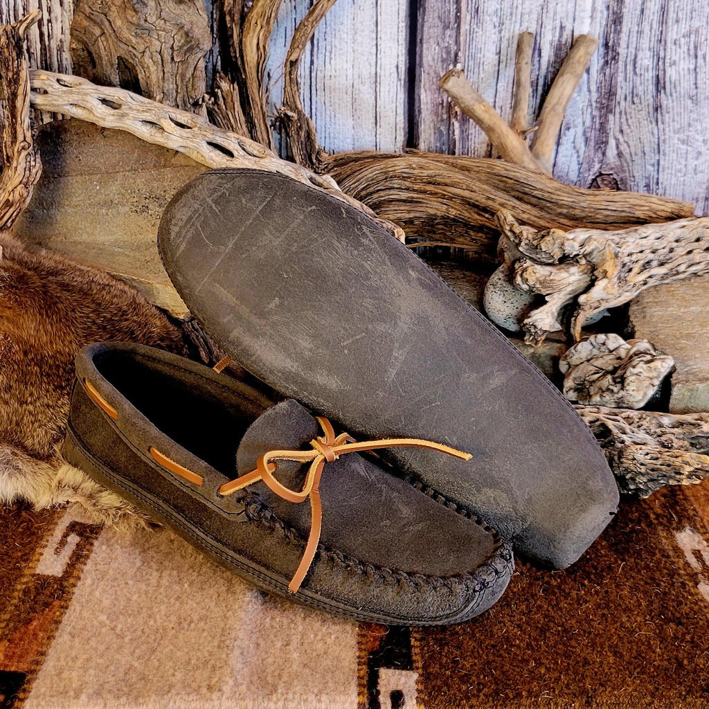 Pair of gray moccasins with rawhide laces and double soft sole exterior.