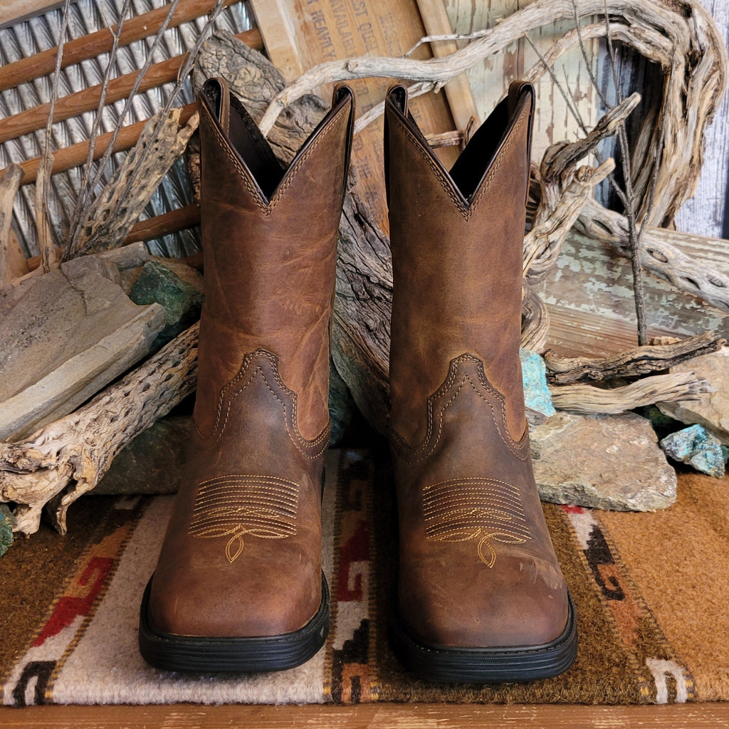 Brown leather boot with weathered appearance and cowboy stitching on the toe.