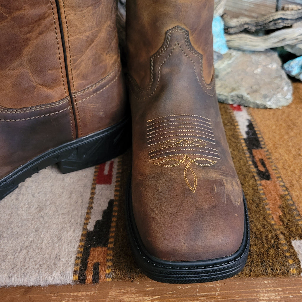 Brown leather boot with weathered appearance and cowboy stitching on the toe.