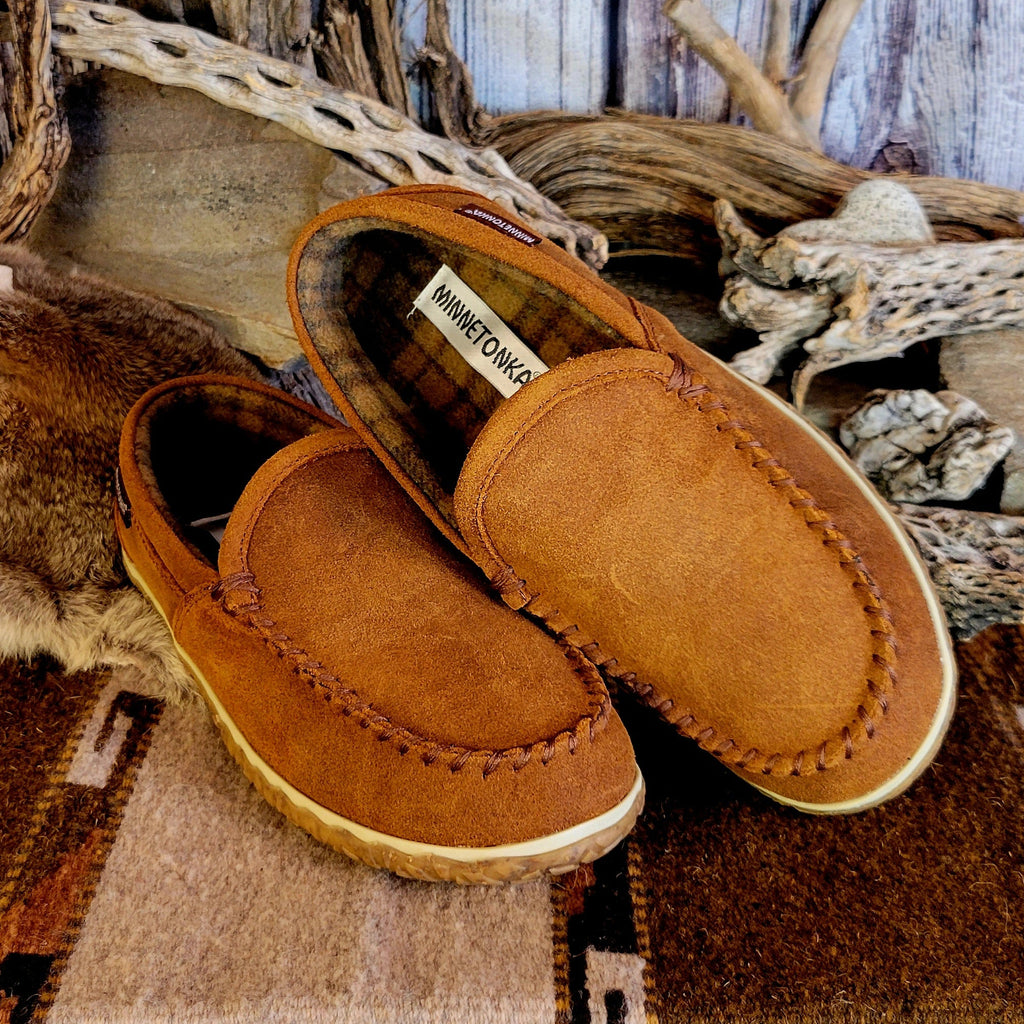Pair of tan moccasin slippers with plaid, lined interior.