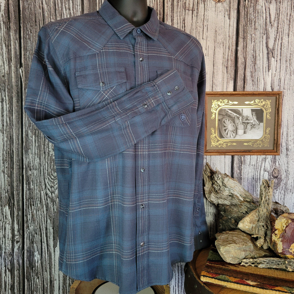 Blue plaid shirt with dual chest pockets and pearl snap closure.