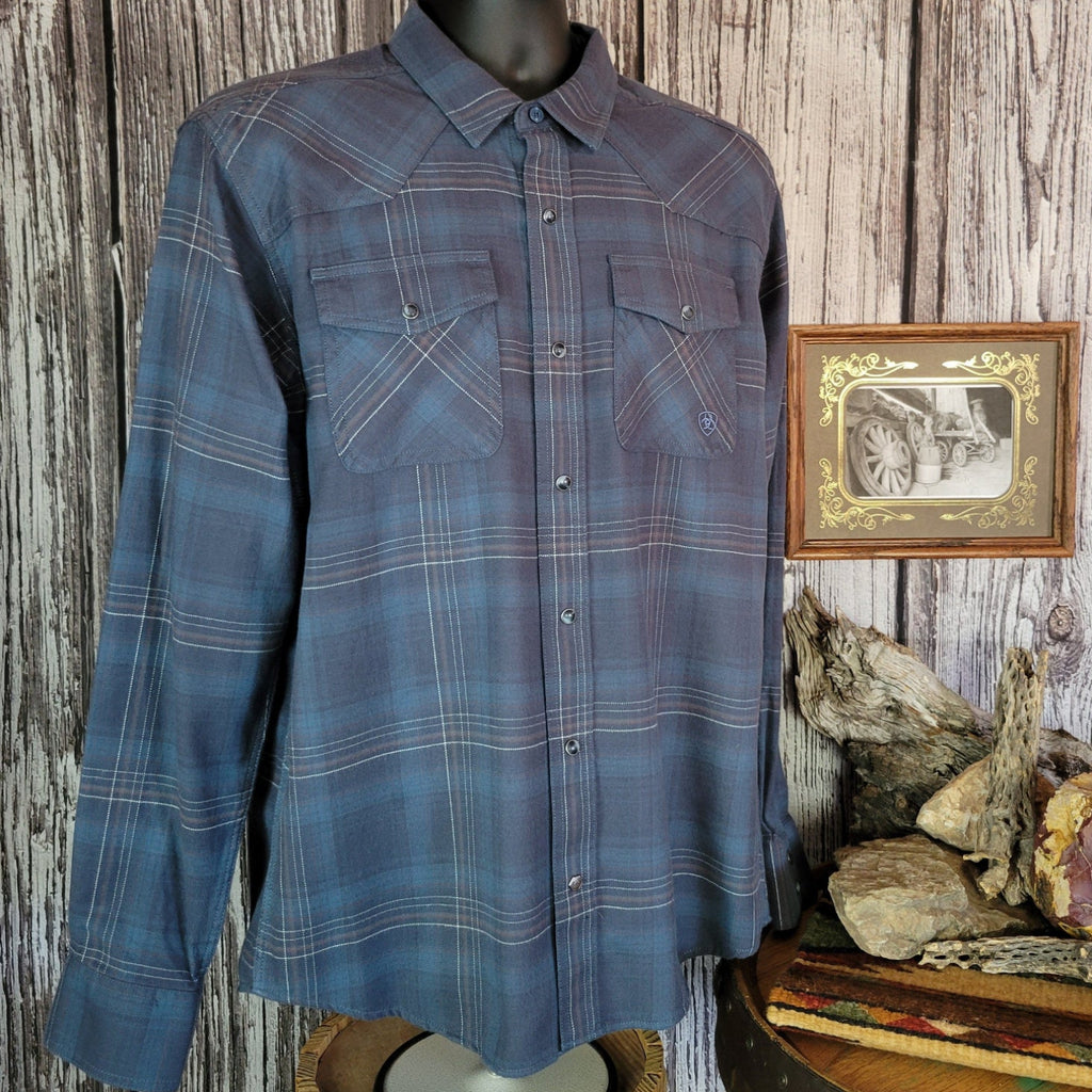 Blue plaid shirt with dual chest pockets and pearl snap closure.