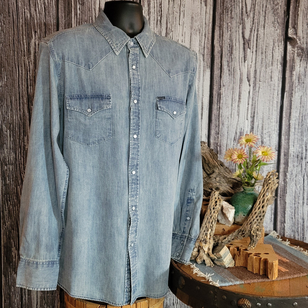 A light denim long sleeve shirt with snap buttons and two chest pockets.
