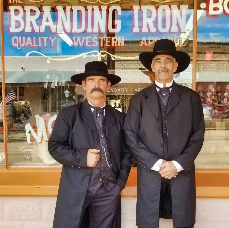 men dressed as wyatt earp and doc holliday in western dusters and hats