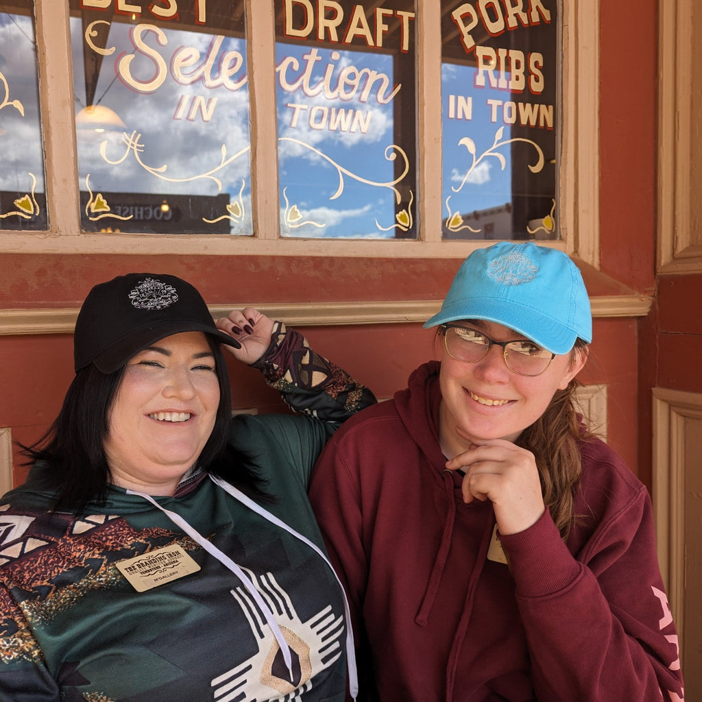 two young women wearing 1879- Tombstone ball caps in Tombstone arizona