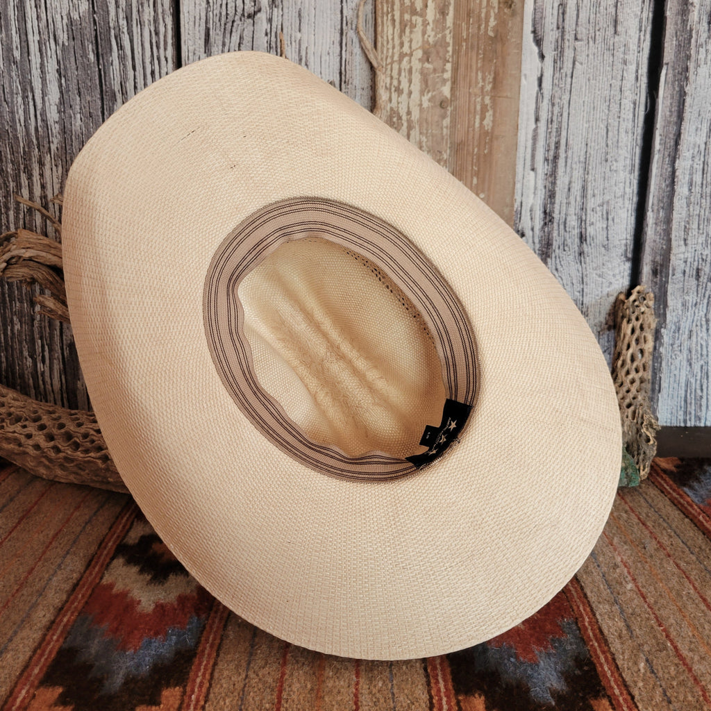 The interior of the straw hat features a tan sweatband with a tag.