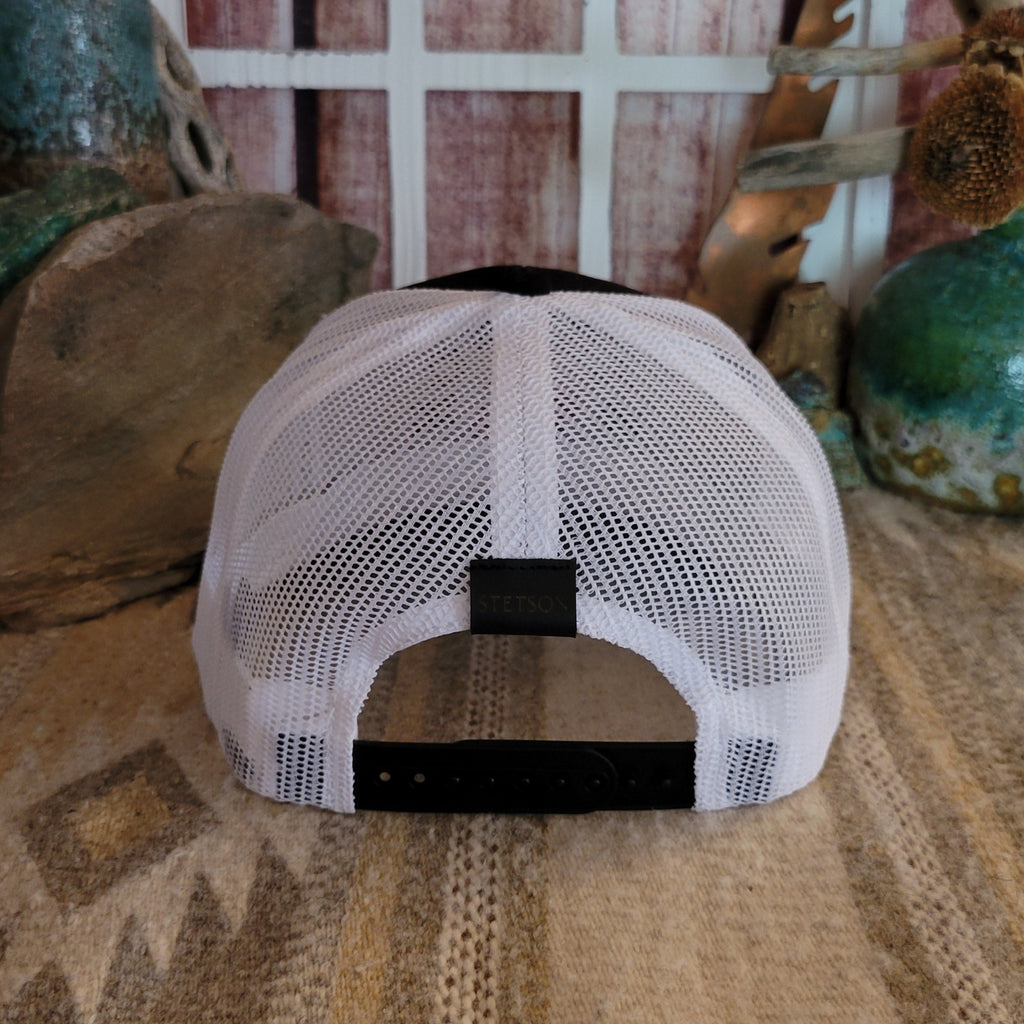 The cap’s back shows a mesh panel with an adjustable snap-back closure.