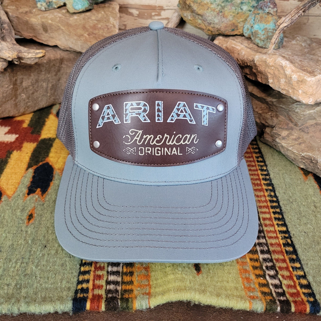 A light gray trucker cap with a brown leather patch.