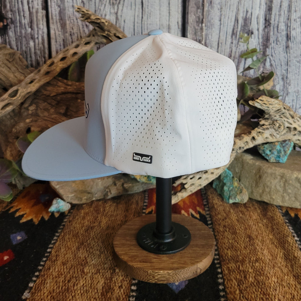 Light blue cap with a dark blue logo and white breathable fabric panel.