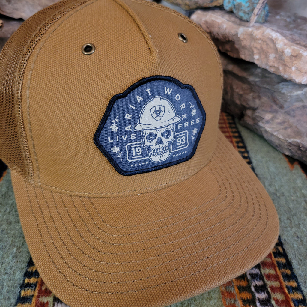A close-up of the patch showing a skull, Ariat brand, and slogan.