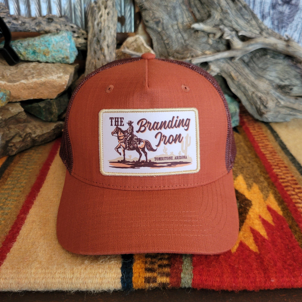 Rust orange cap with The Branding Iron logo patch.
