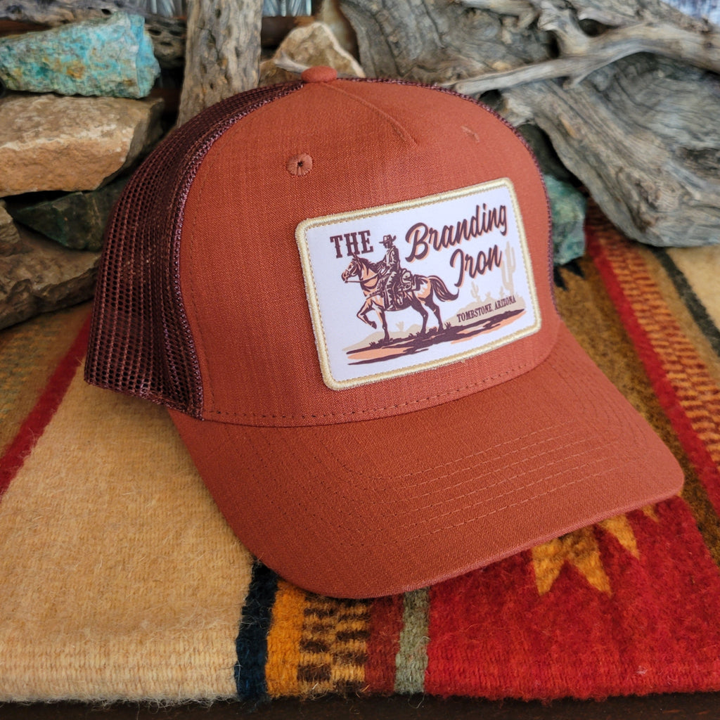 Rust orange cap with The Branding Iron logo patch.