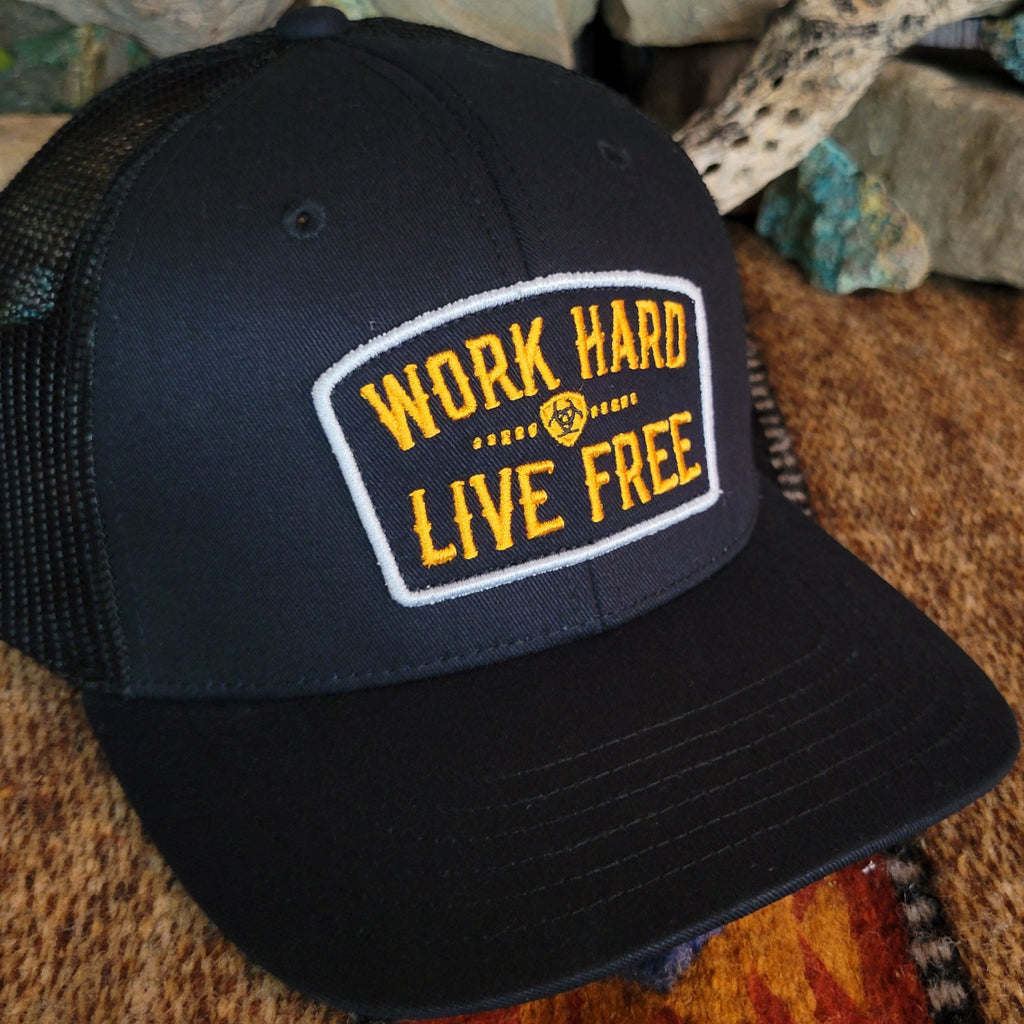 A close-up of the cap's patch with "work hard, live free" embroidered.