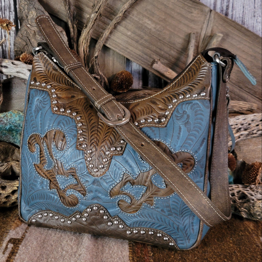 Leather tote bag with studded details, blue stain, and hand-tooled design.