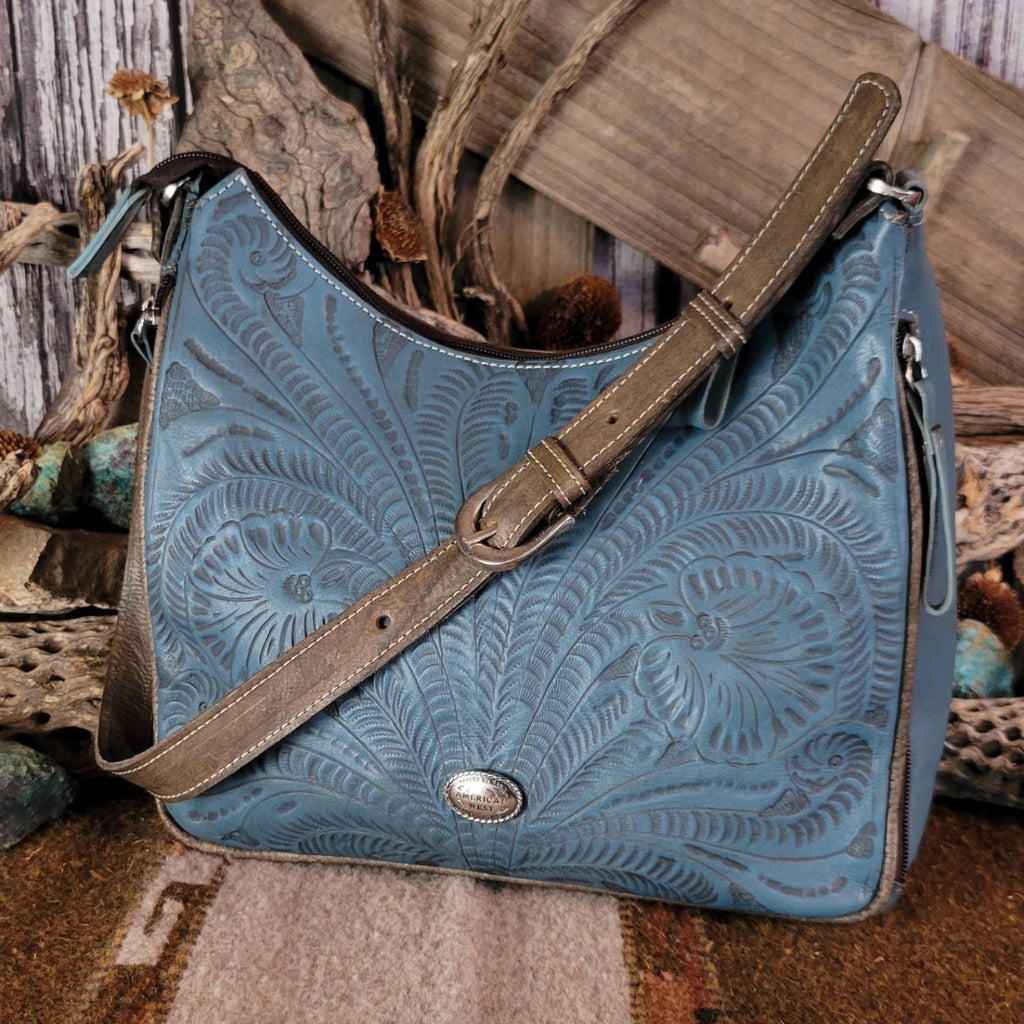 Leather tote bag with studded details, blue stain, and hand-tooled design.