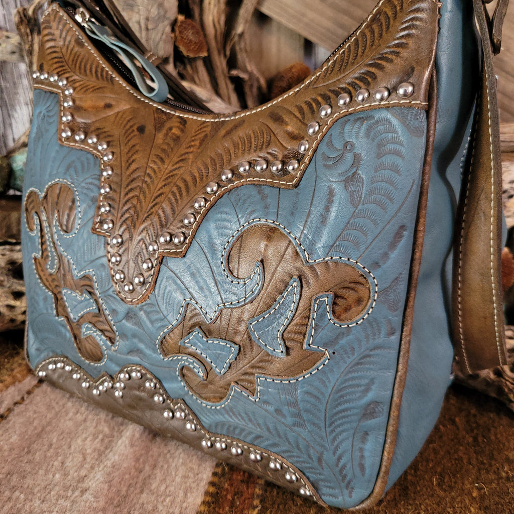 Leather tote bag with studded details, blue stain, and hand-tooled design.