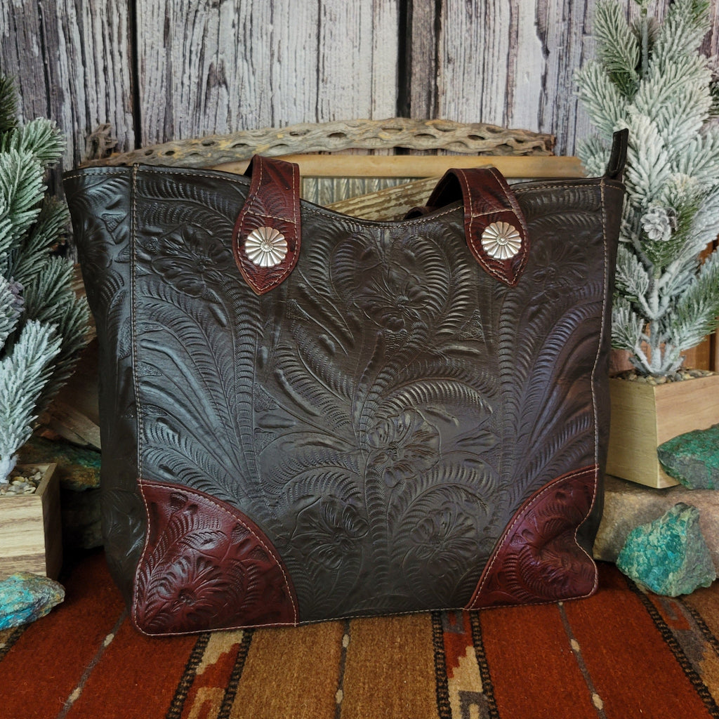 Hand-stained leather tote bag with floral hand-tooled designs and red and dark brown coloring.