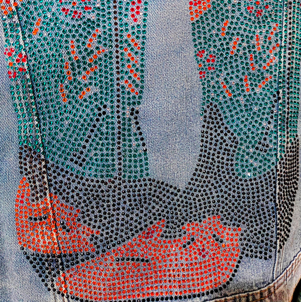 Distressed light blue denim jacket featuring a vibrant bedazzled cowgirl boots design on the back by Forward Design