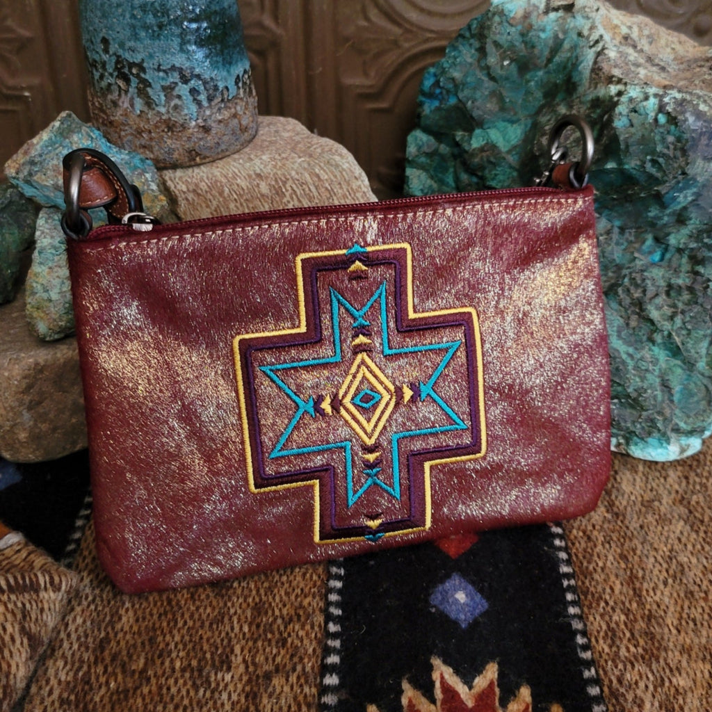 Embroidered clutch with leather accents and vibrant designs.